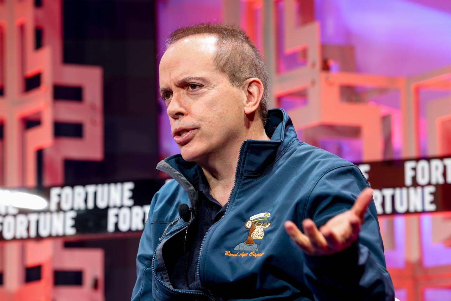 Man wearing blue jacket speaking on stage