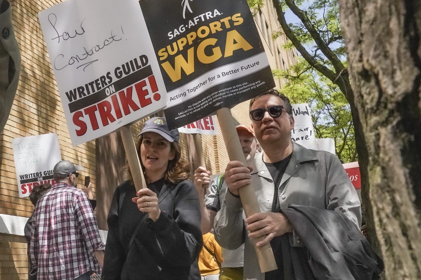 Actors and comedians Tina Fey, center, and Fred Armisen, right, join striking members of the Writers Guild of America on the picket line during a rally outside Silvercup Studios, on May 9, 2023, in New York.