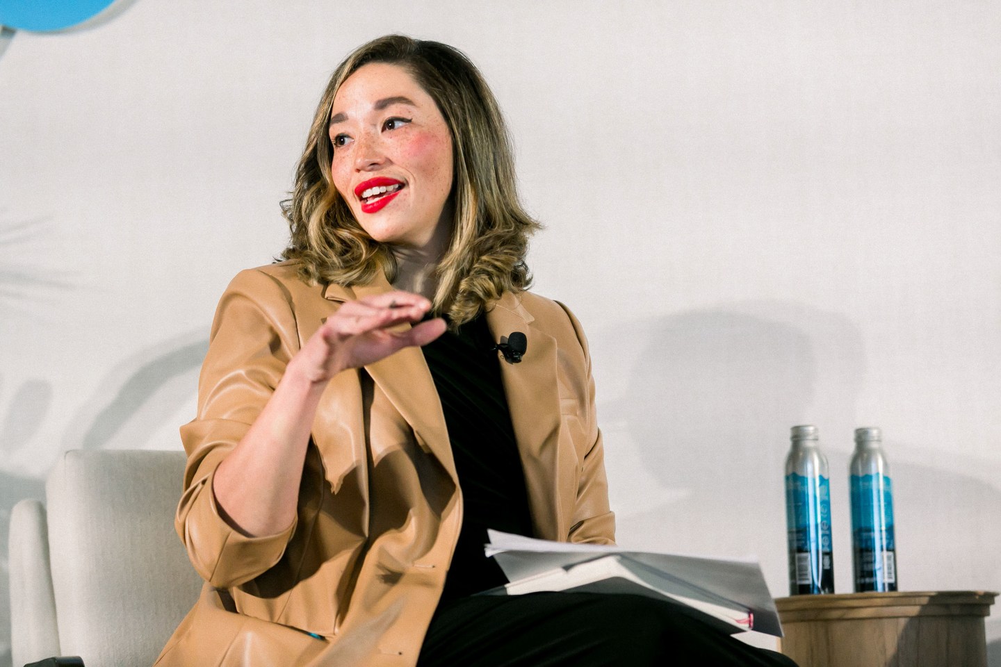 woman in professional clothing sitting onstage