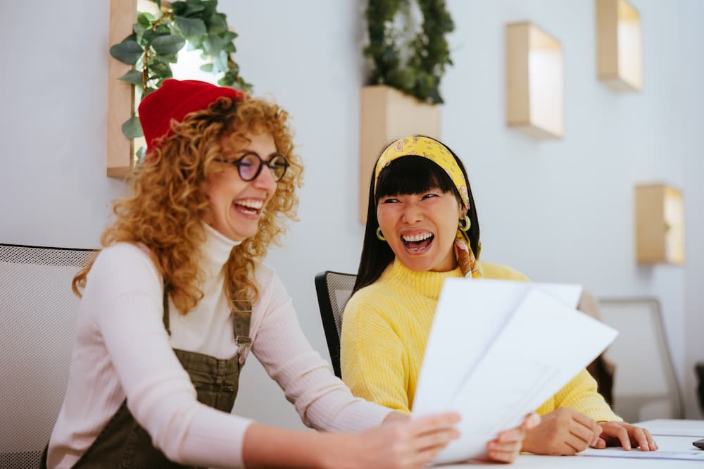 Photo of two women smiling in a workplace