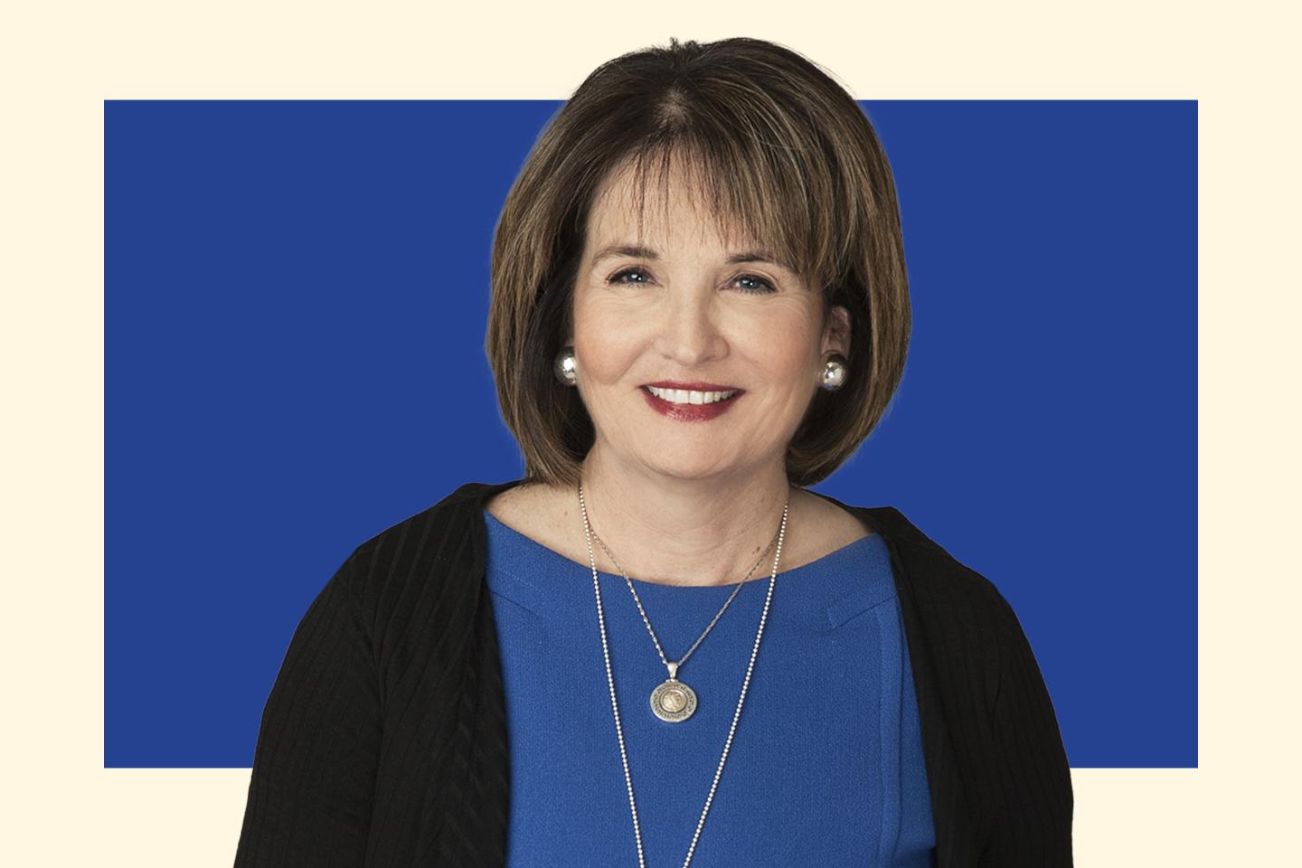 Smiling woman standing in front of blue background