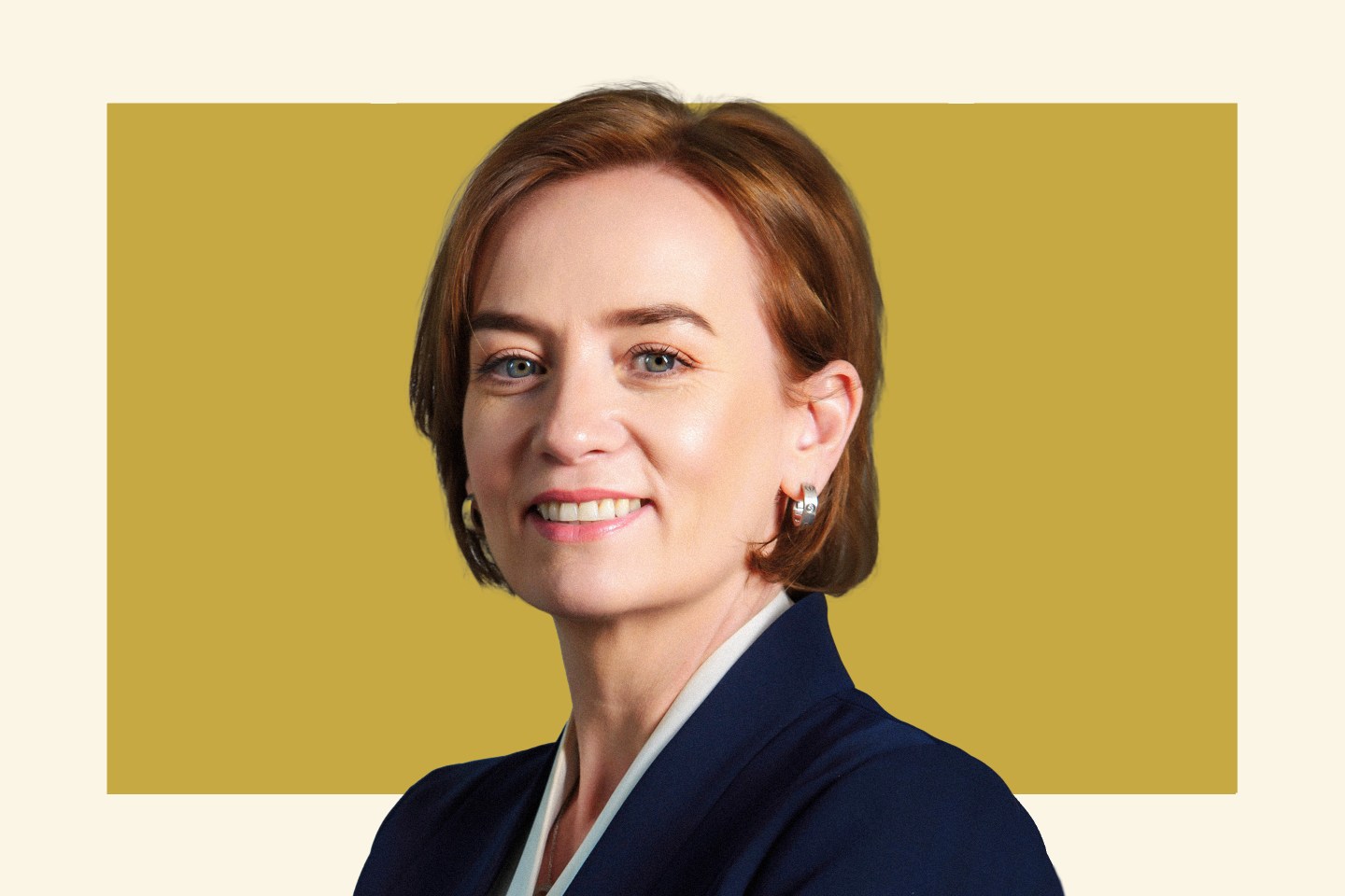 women with short brown hair wearing suit jacket and smiling