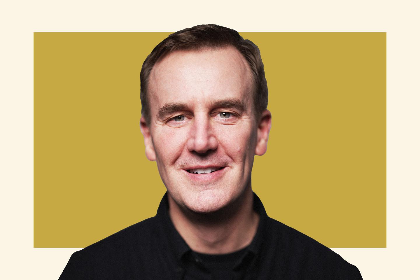 Man smiling in front of yellow background