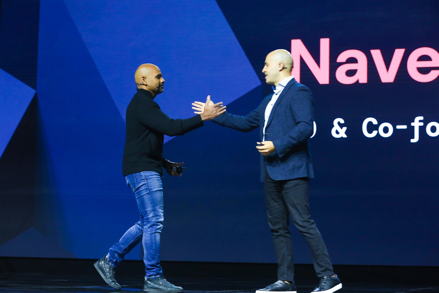 two men shaking hands onstage