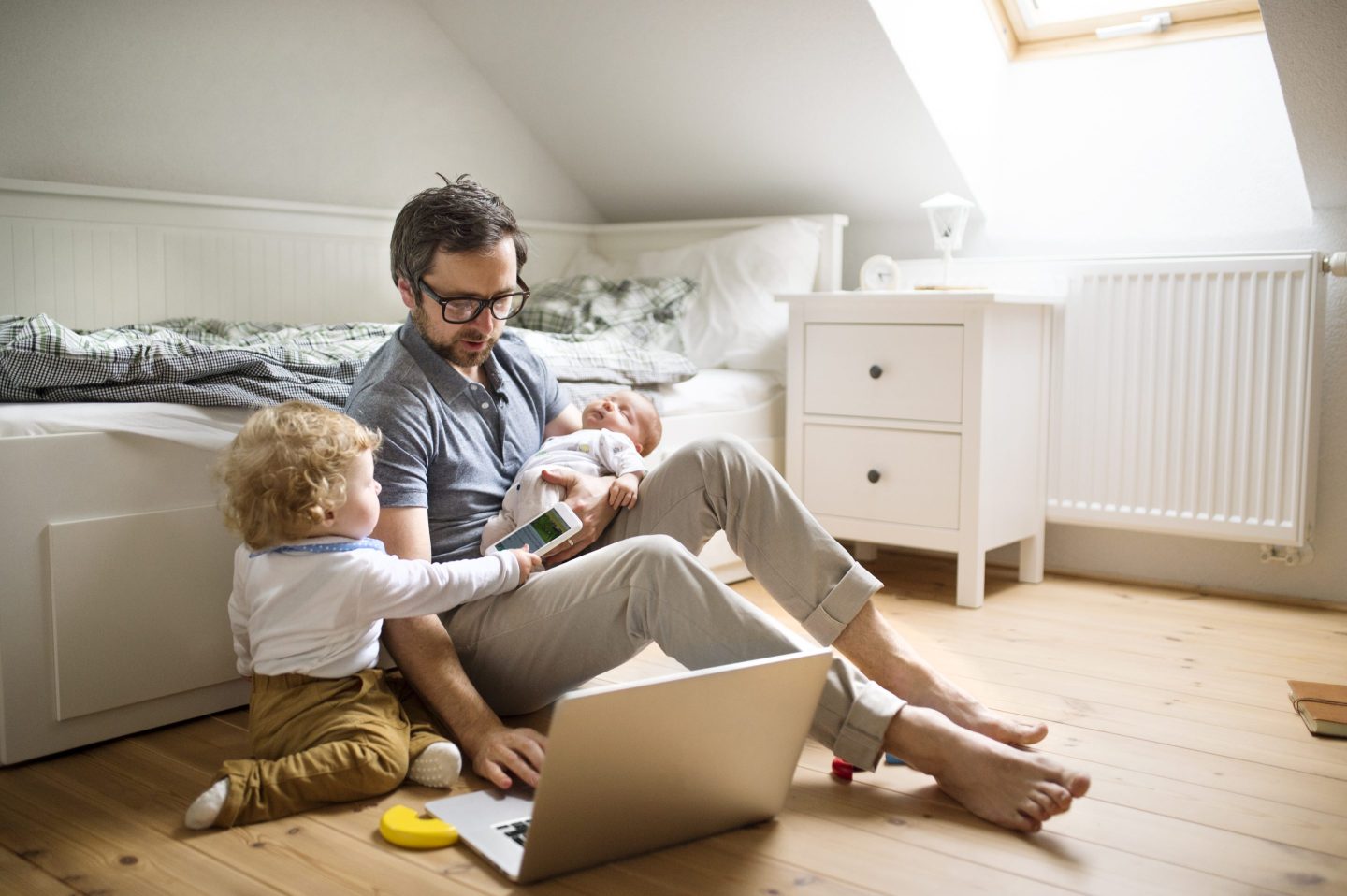 Father with his little son and baby daughter working from home