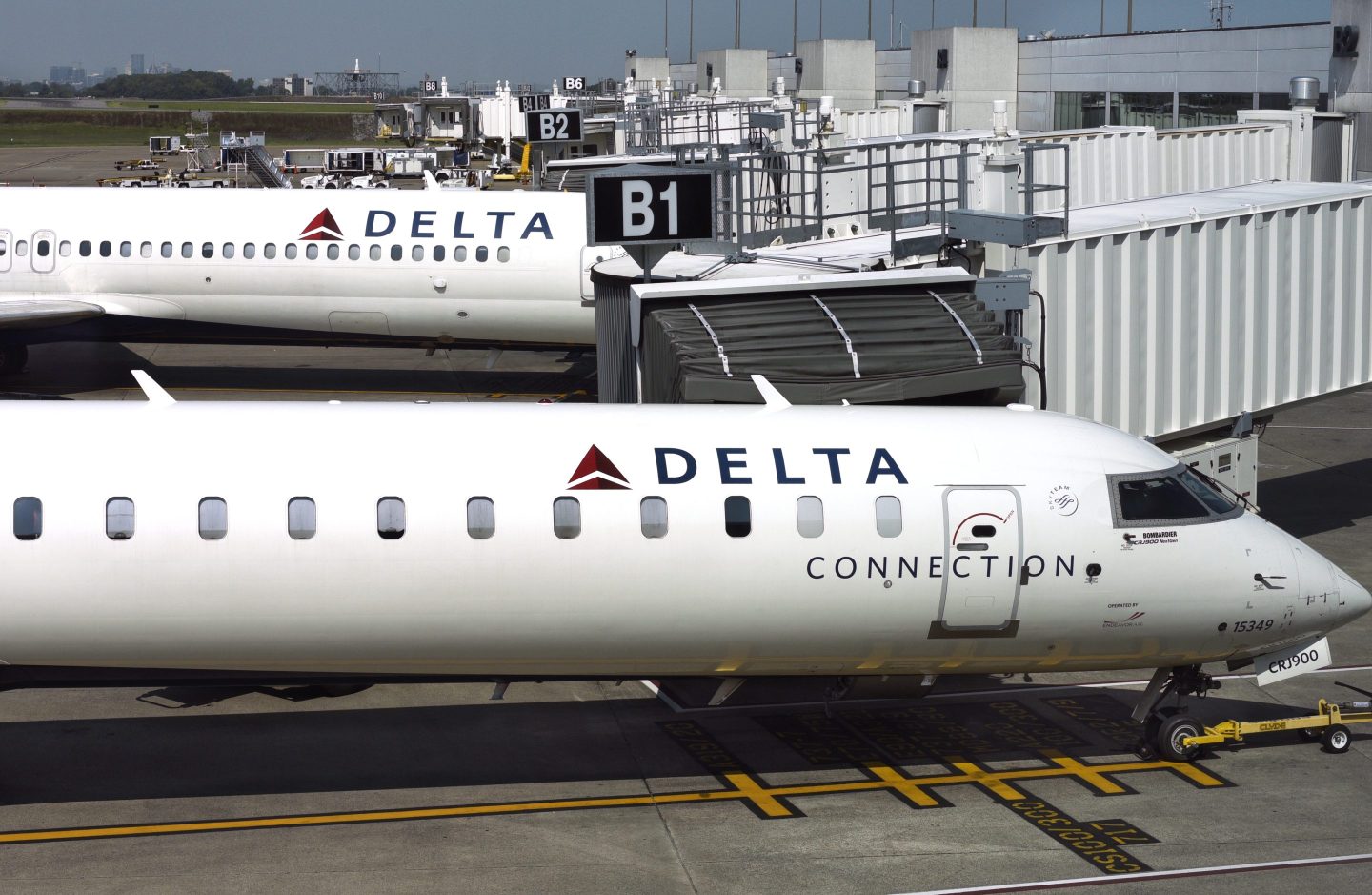 A Delta Connection passenger jet (Bombardier CRJ900) parked at a gate beside a Delta Airlines plane at Nashville International Airport