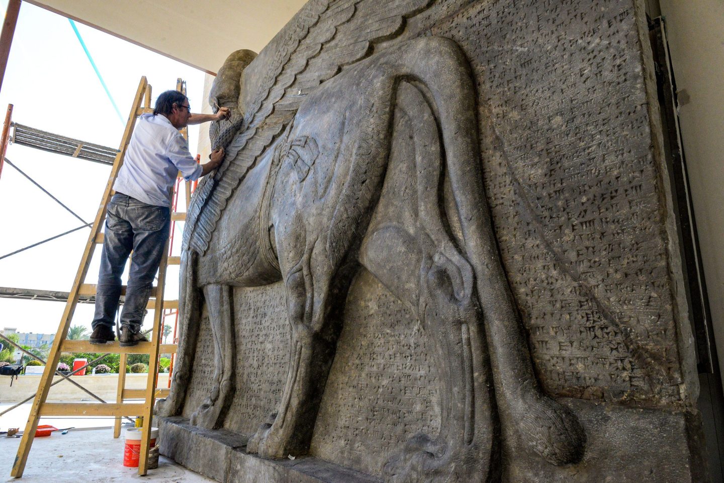 Man works on a replica of an Assyrian protective deity at the University of Mosul in Iraq