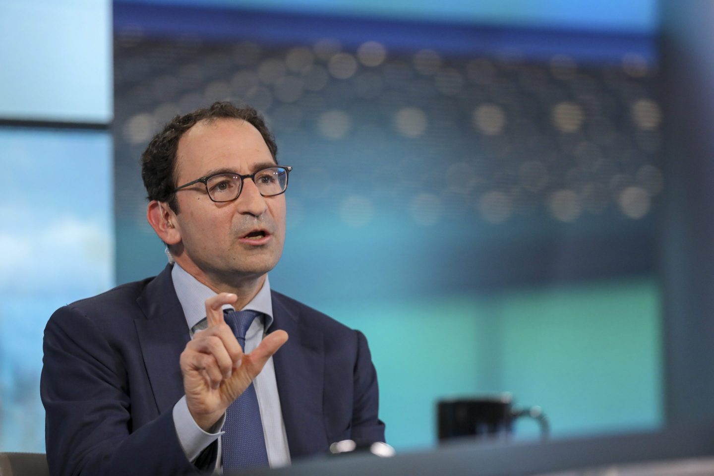 Man in glasses and a suit speaking at a podium