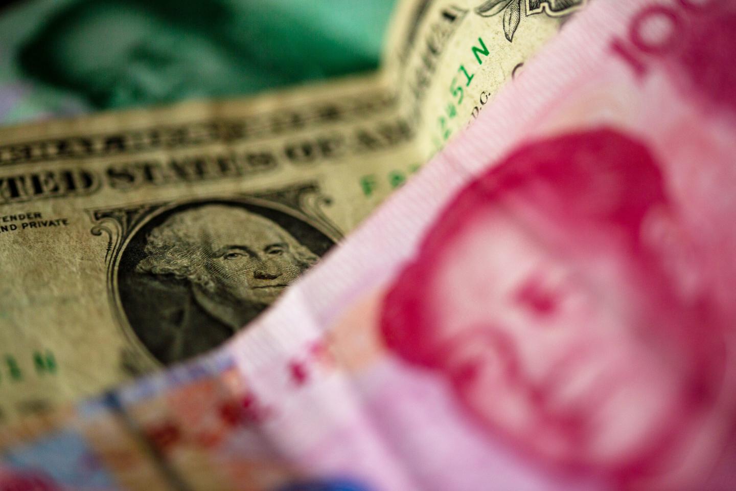 A Chinese 100 yuan banknote and a 1 US dollar bill are lying on a table.