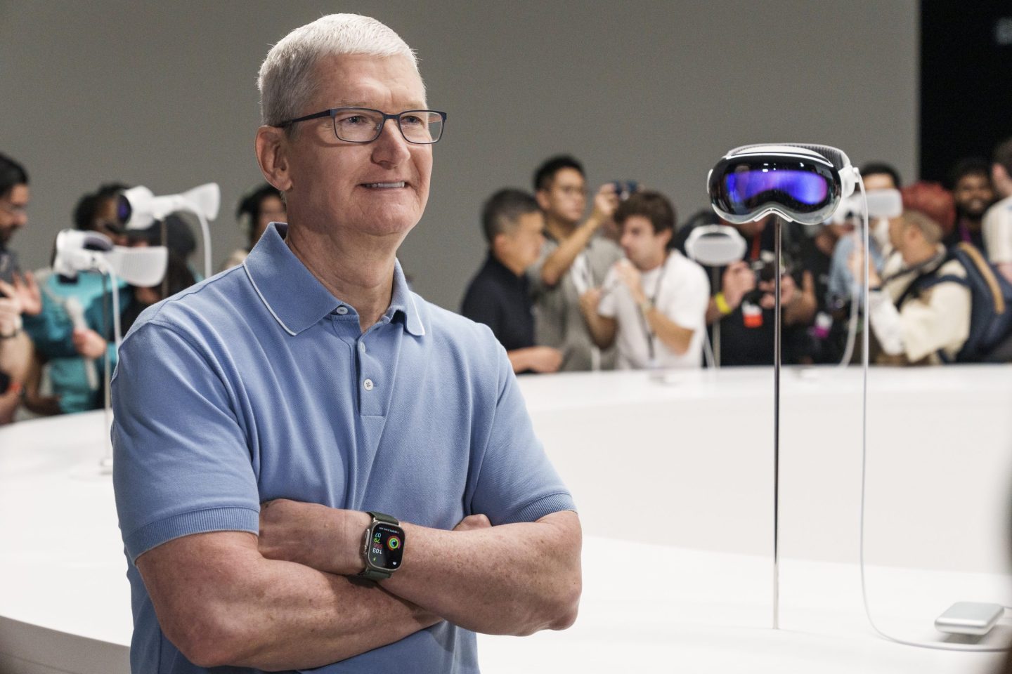 Tim Cook, chief executive officer of Apple Inc., beside an Apple Vision Pro mixed reality (XR) headset .