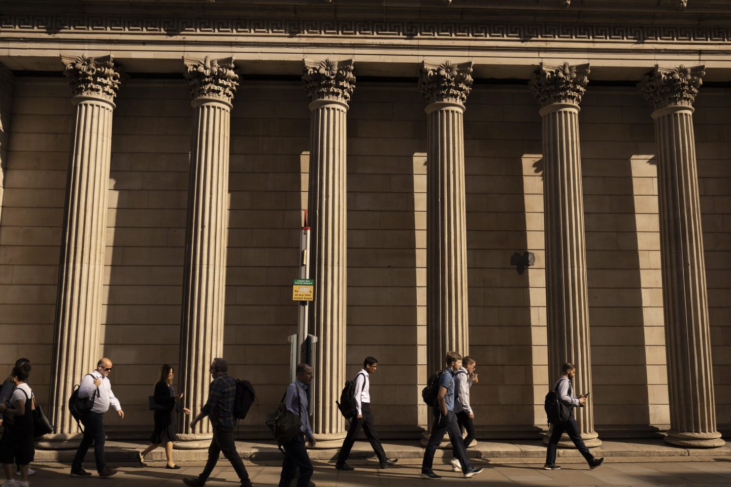 Commuters pass the Bank of England (BOE) in the City of London on Jun. 19,