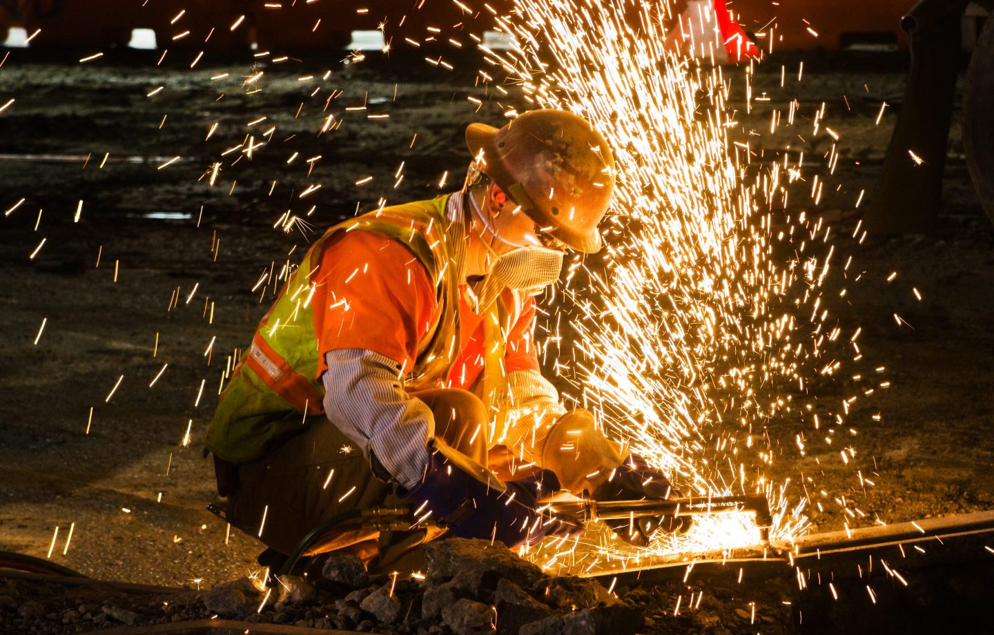 Welder cutting track rail with an oxy-acetylene cutting torch.