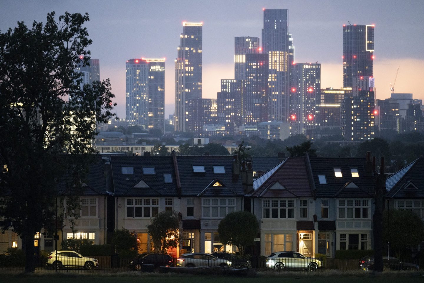 Lit porches of a terraced period houses and in the distance, the growing development at Nine Elms at Battersea, seen from Ruskin Park, a south London green space in Lambeth