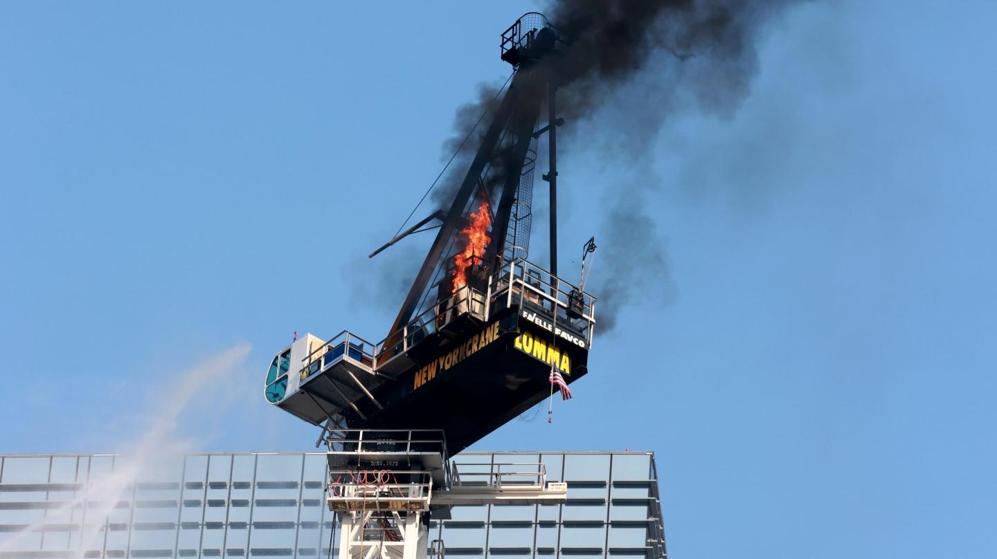 A burning construction crane is seen atop a high rise near Manhattan's Hudson Yards