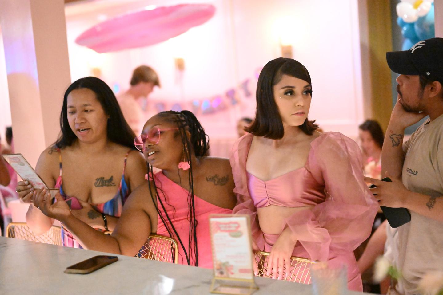 Samantha Cruz (2nd R) gathers at the bar with friends while attending a Barbie themed pop up celebration