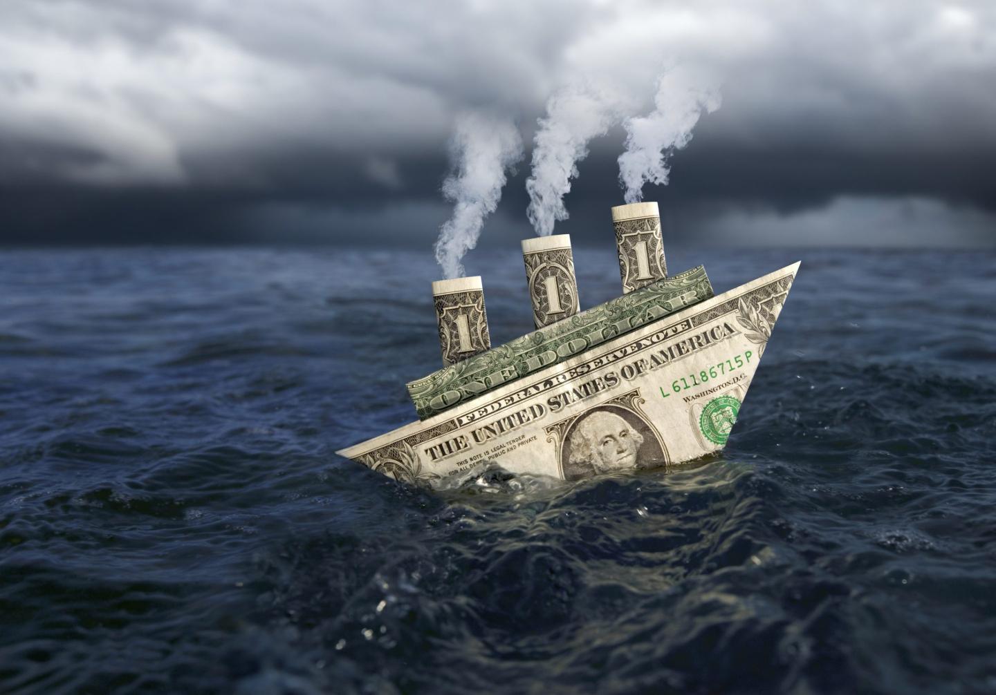 A sinking paper boat made of U.S. dollars