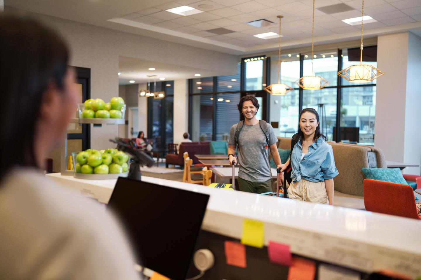 A Hilton team member meets with guests before checking in.