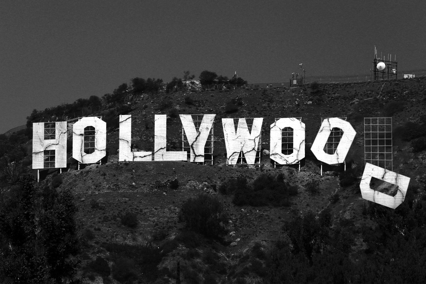 Photo illustration of the famous Hollywood sign, but the sign is cracking and crumbling, the "D" at the end has fallen off, and the "O" next to it is starting to fall as well.