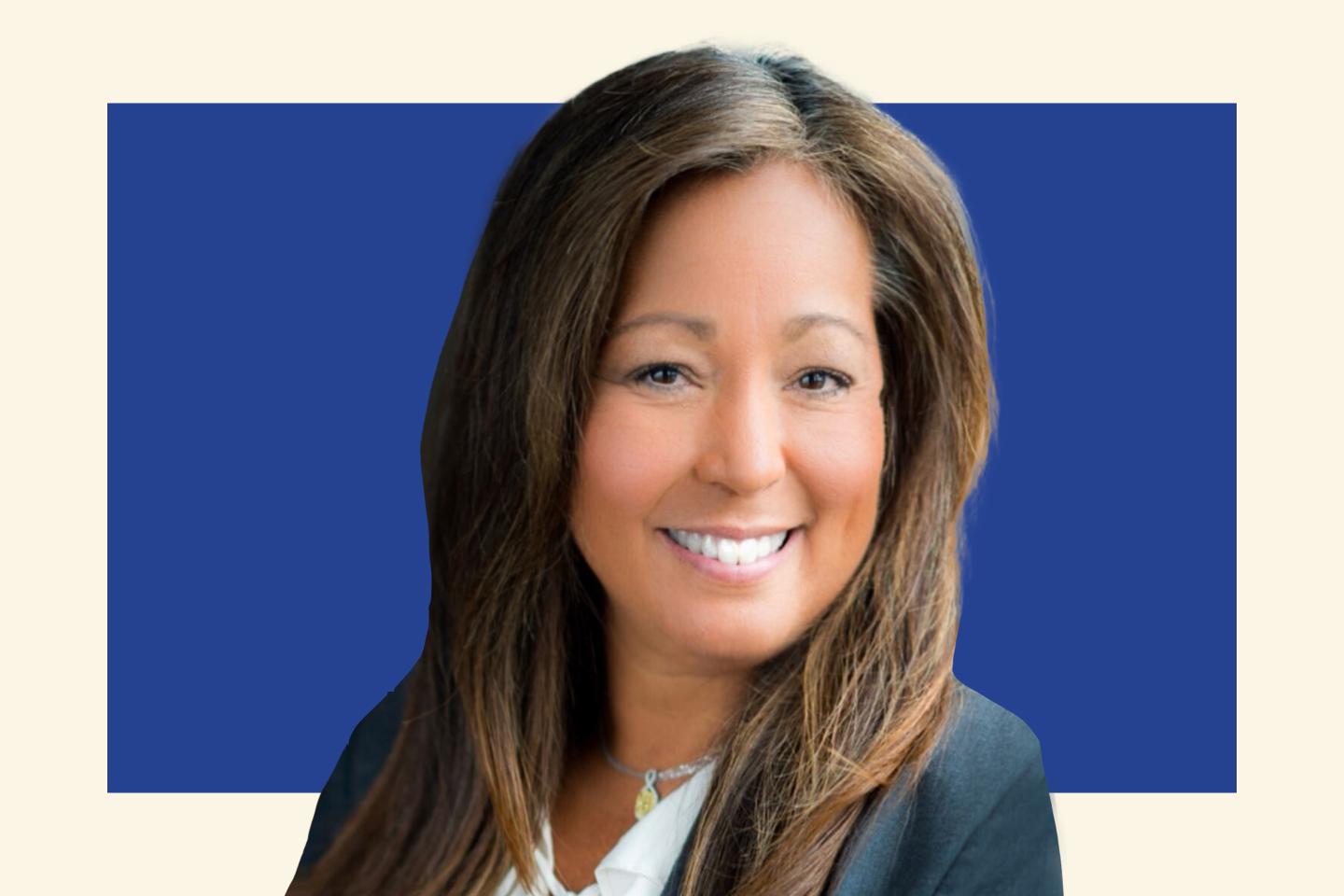 brunette woman in suit jacket and collared shirt smiling