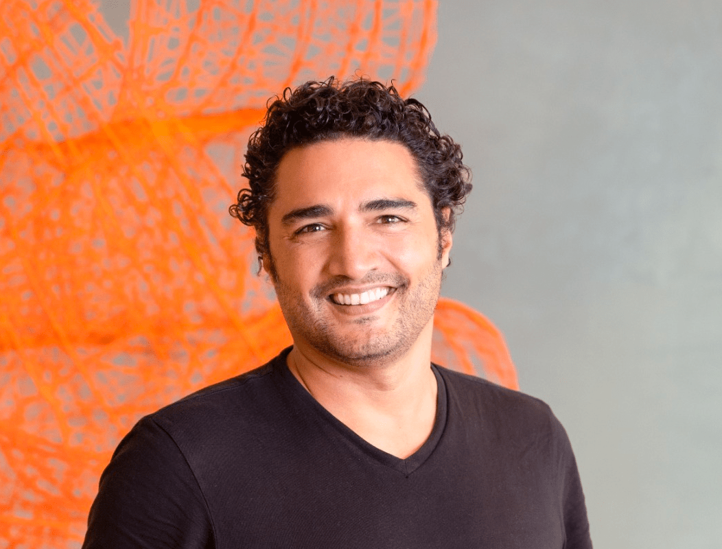 Man with dark curly hair wearing a black t-shirt