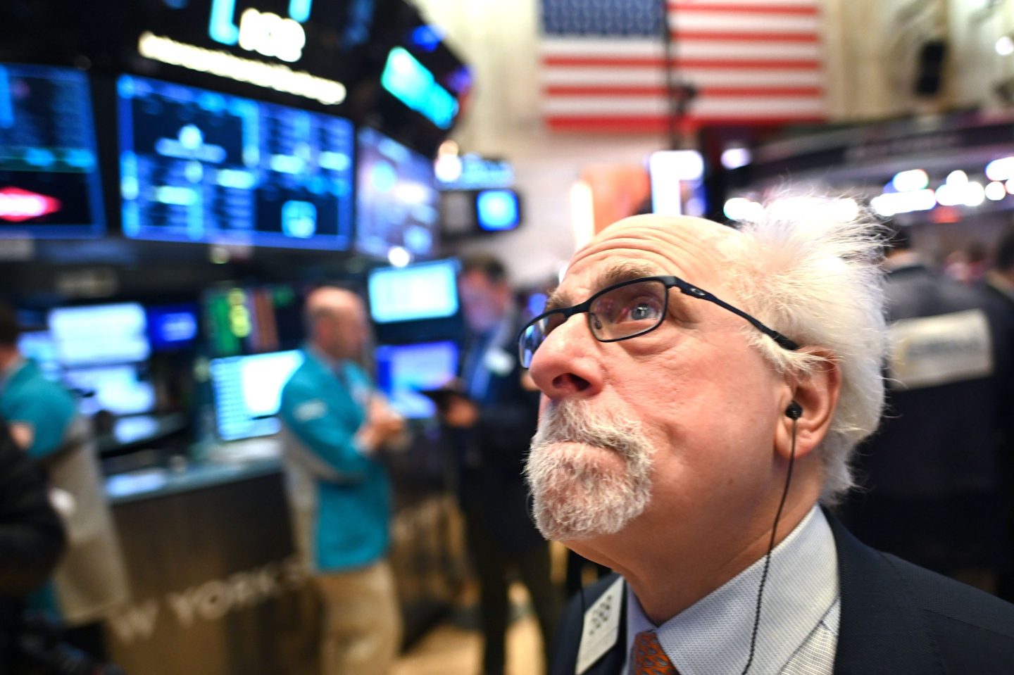 A worried stock market trader looks up at the big board.