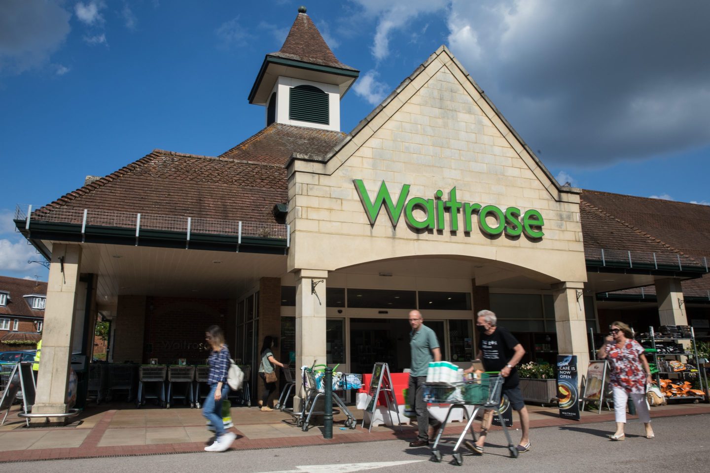 People walking in frtong of a Waitrose store