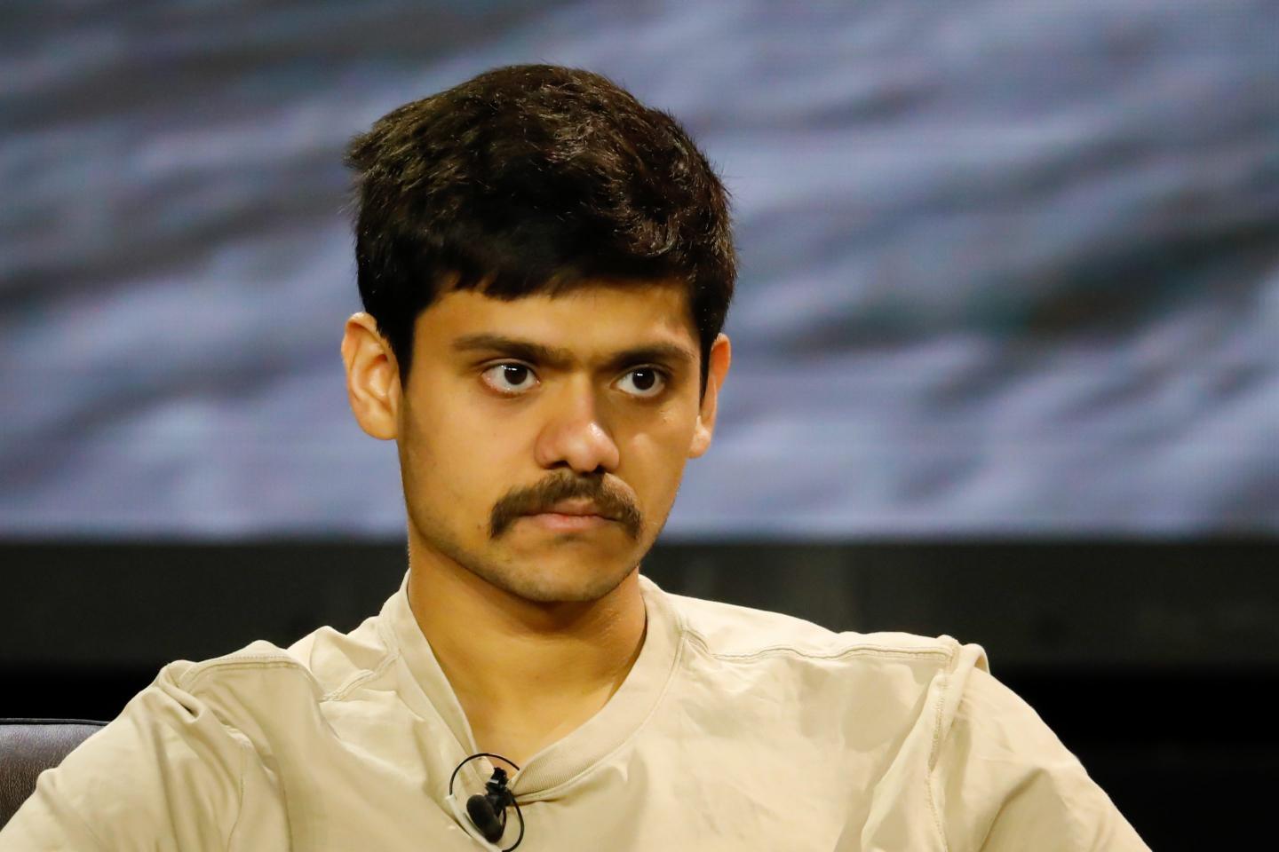 Kanav Kariya speaks on stage at a conference.