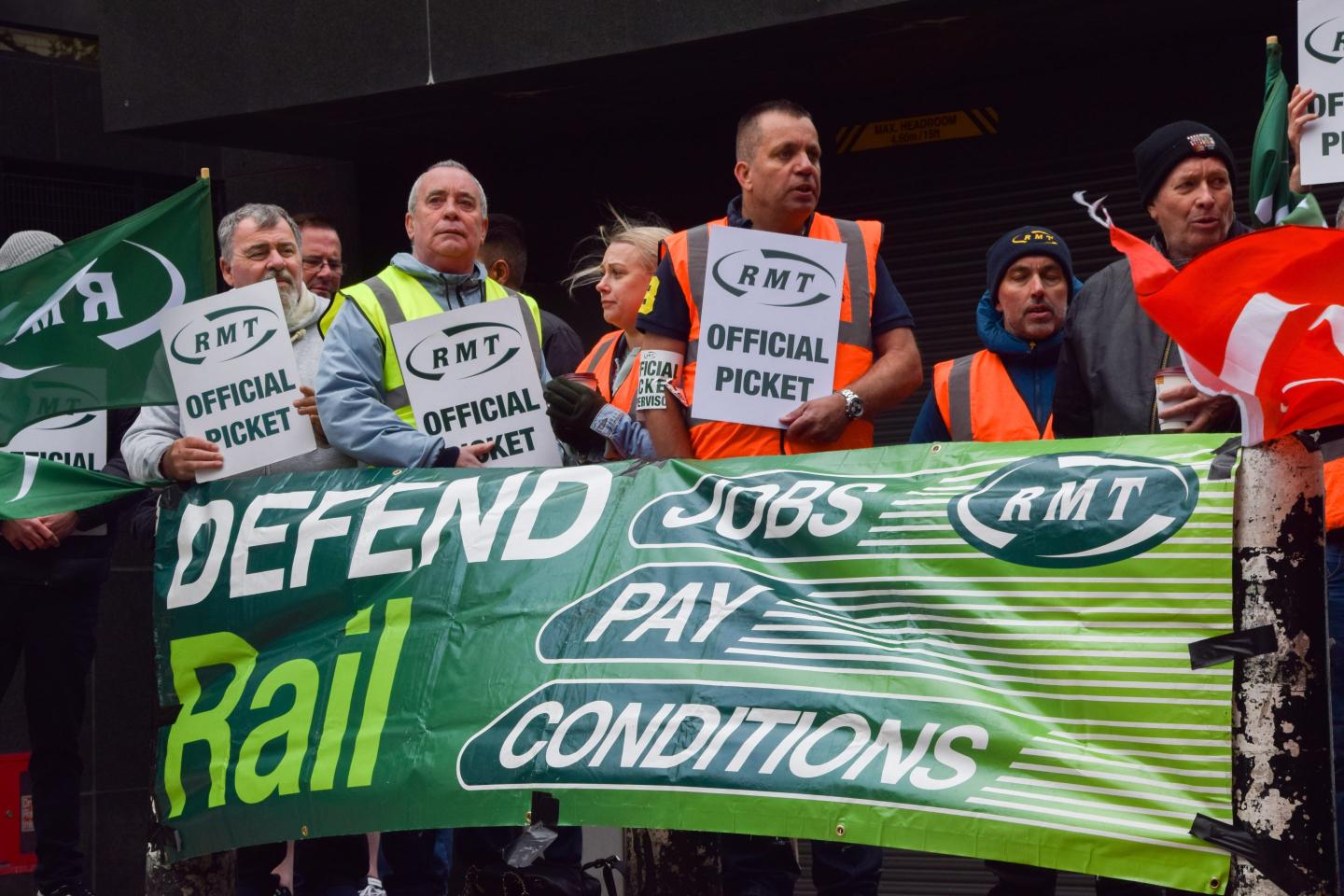 a group of workers holding up a sign to "defend rail"