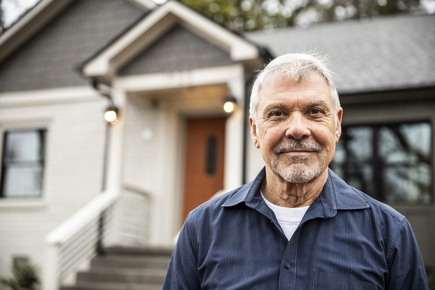 Portrait of senior man in front of home