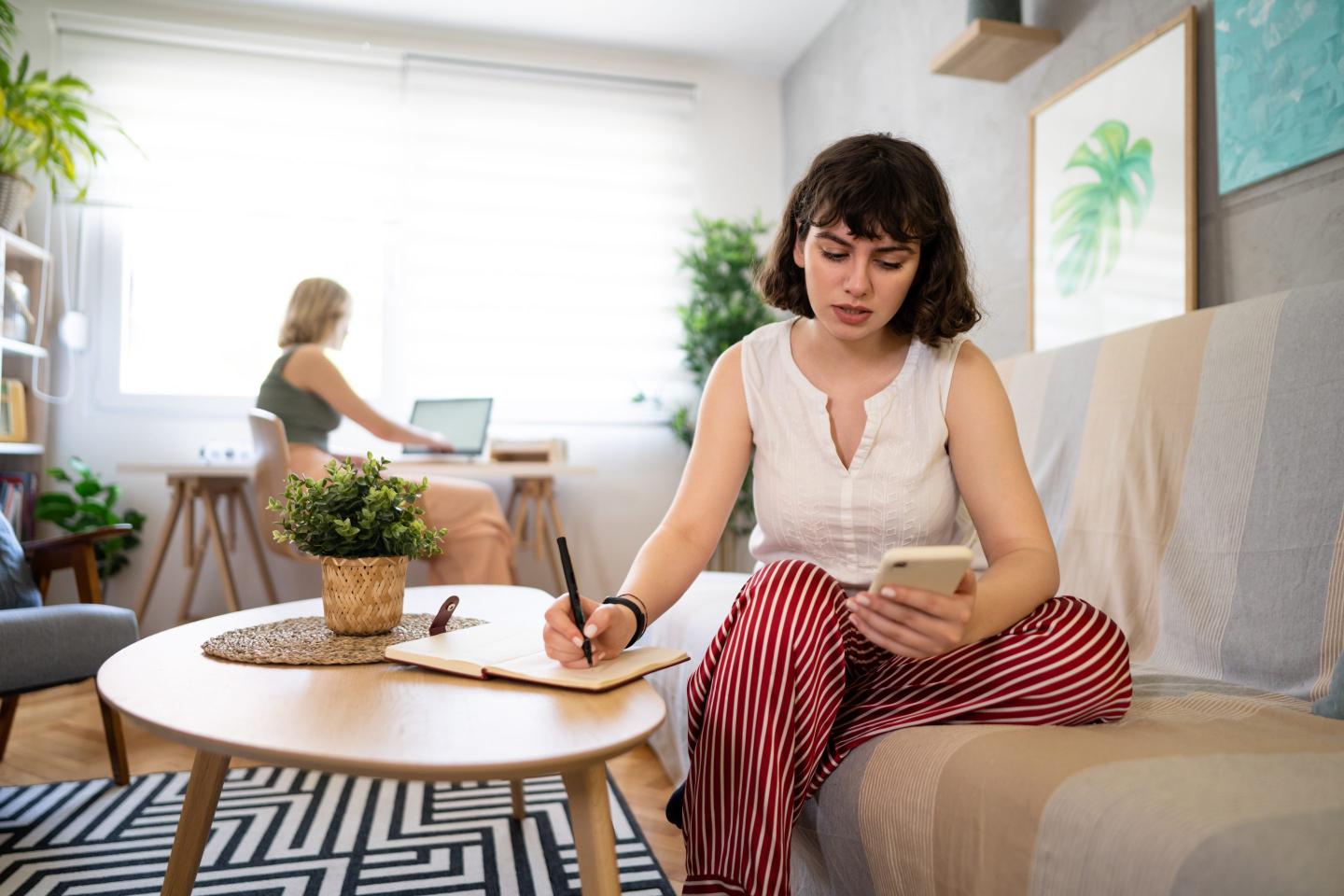 Worried woman looking at her online bank account on mobile phone