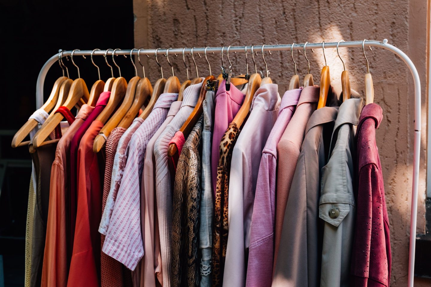 Colorful shirts, jackets, and sweaters hanging on a clothing rack