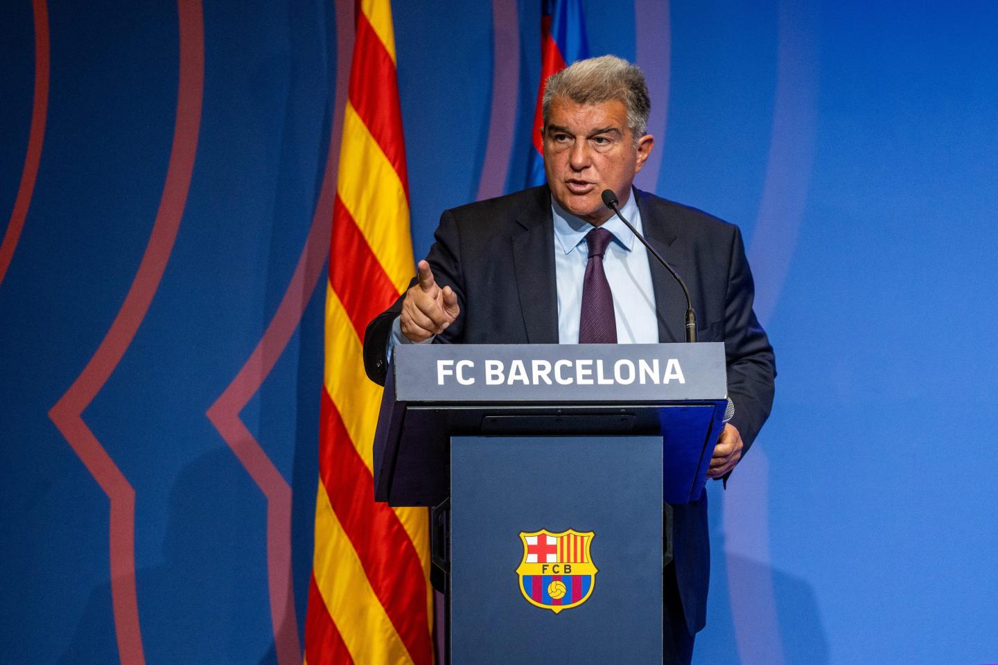 FC Barcelona president Joan Laporta standing at a podium.