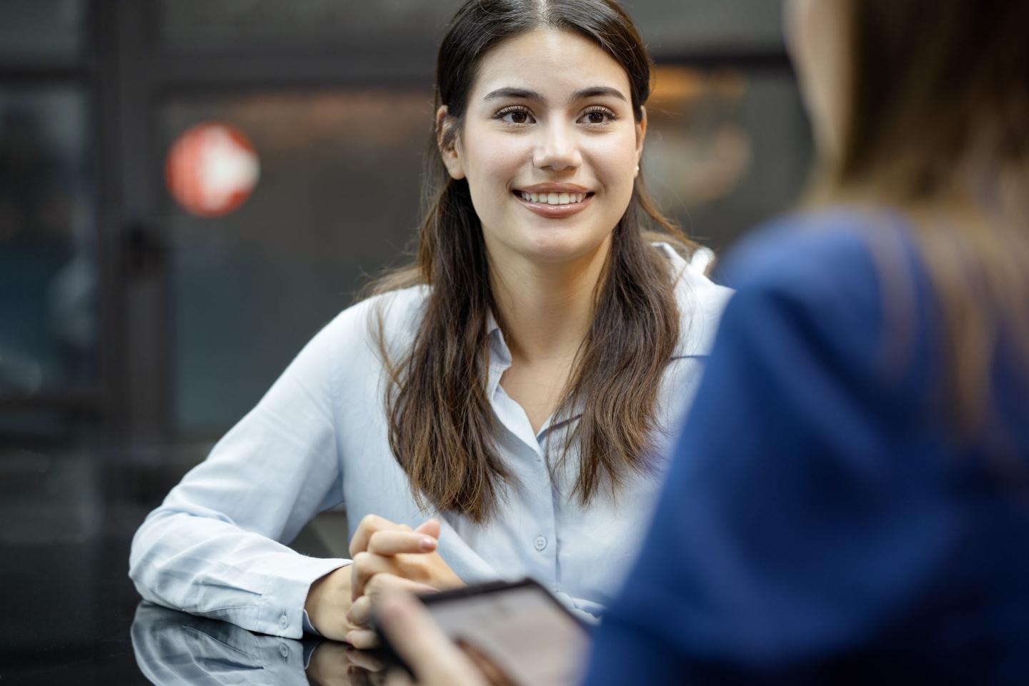 A new female employee on a job interview final round with an HR officer in a business office.