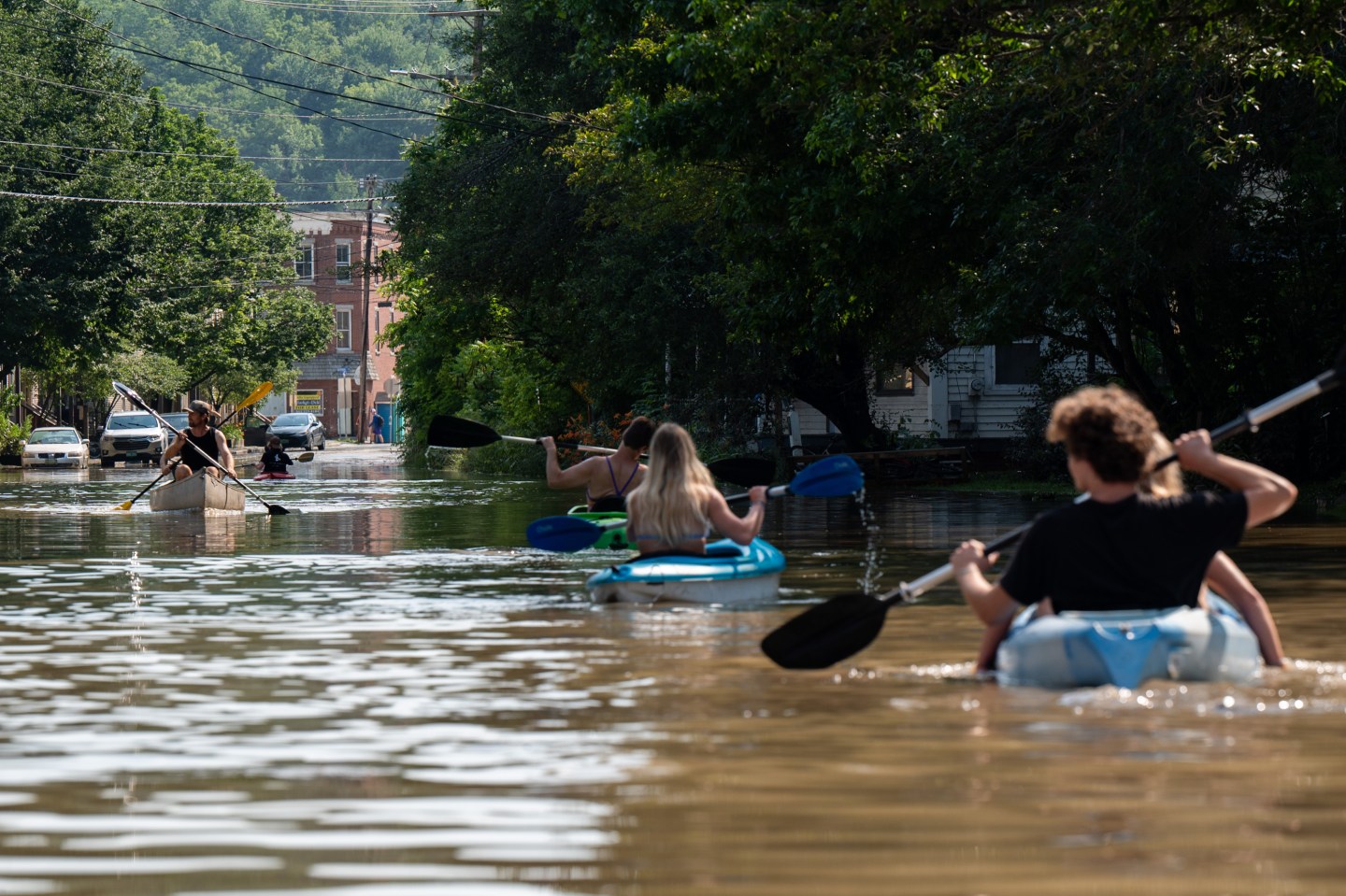 People kayak up and down the flooded waters of Elm Street on July 11, 2023 in Montpelier, Vermont, after eight inches of rain fell over 48 hours.