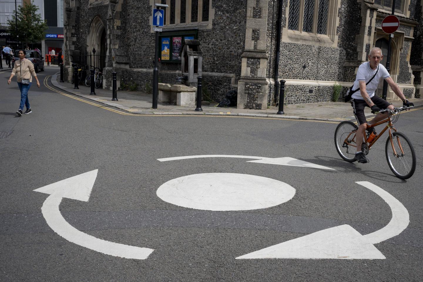 A man rides a bicycle around a roundabout in London.