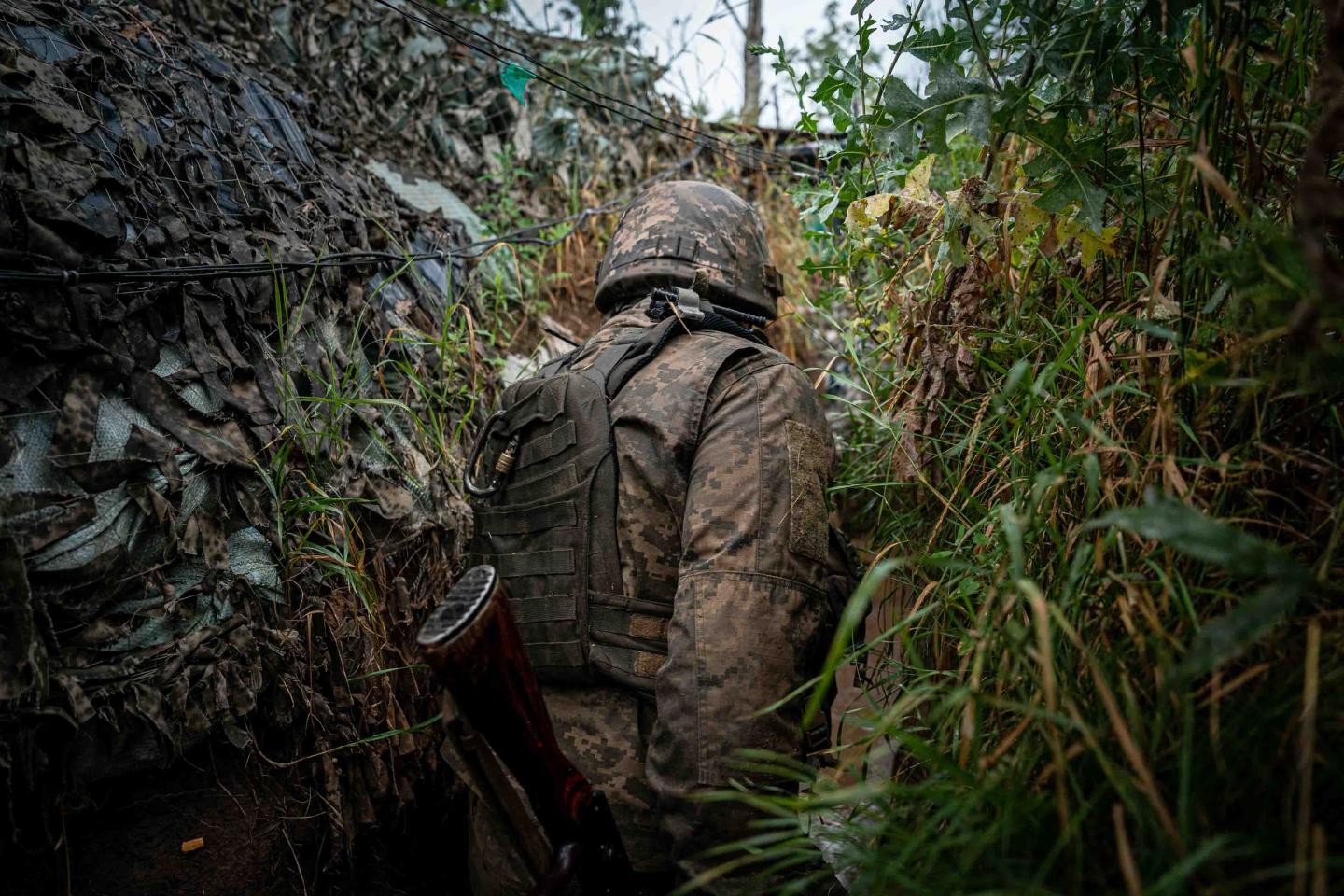 Ukrainian serviceman walks inside a trench on the frontline near as Russia-Ukraine war continues