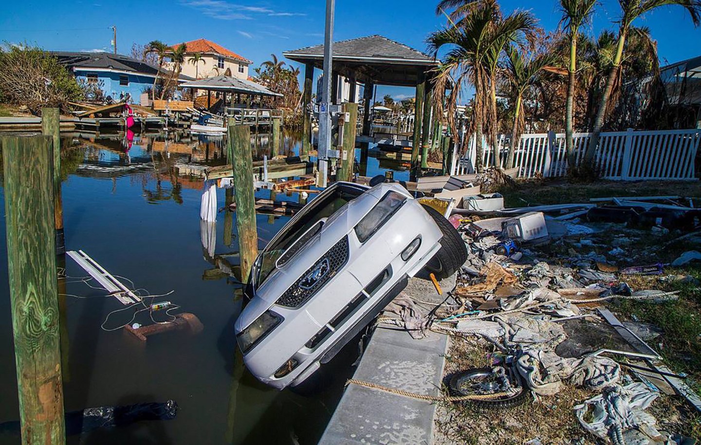 A 2003 Ford Mustang hangs off a seawall behind a house in Fort Myers Beach, Florida, on Oct. 26, 2022. The car was carried away in Hurricane Ian’s storm surge a month earlier.