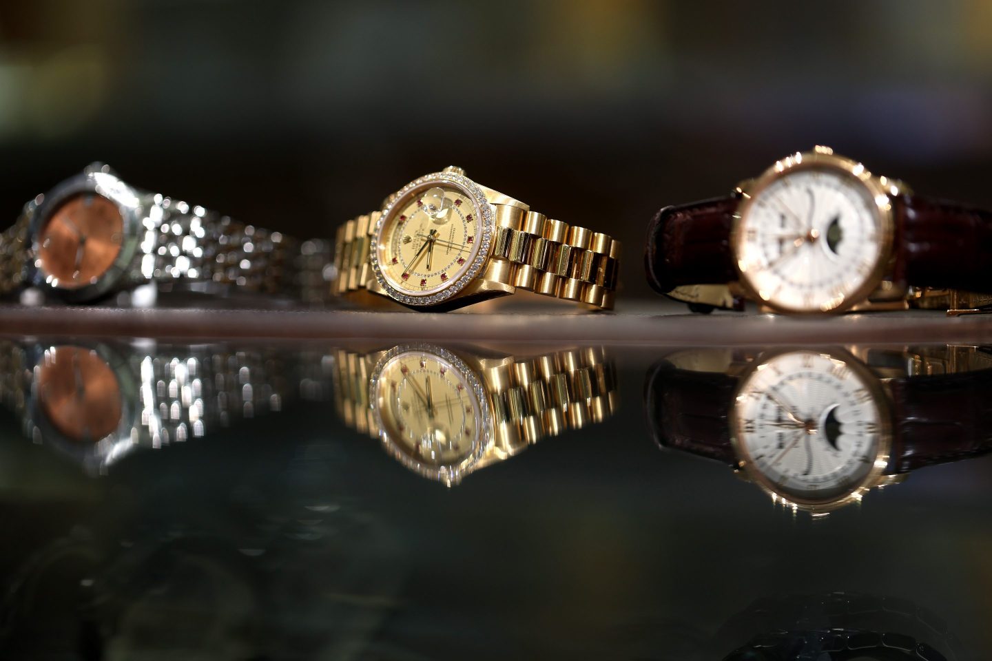 a row of three watches in gold and silver