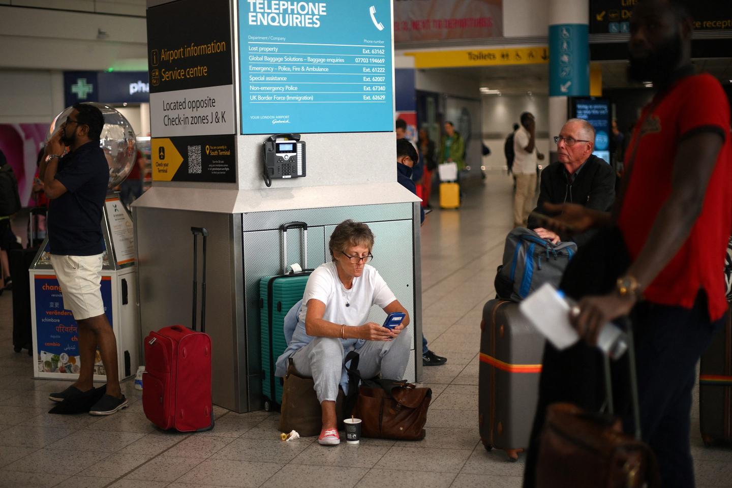 Passengers waiting in an airport amid luggage