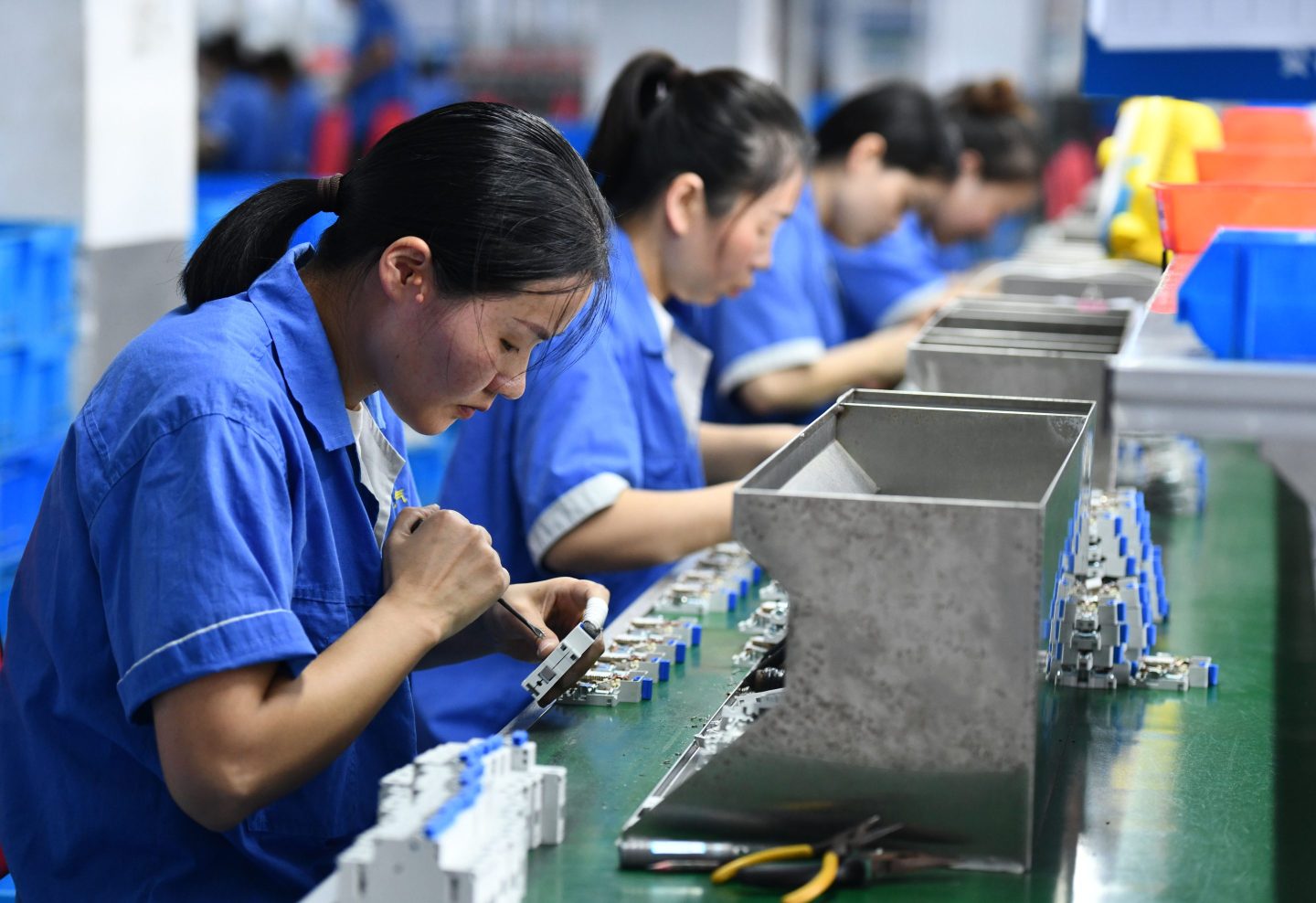 Workers work on a circuit breaker production line at an electric company workshop in Fuyang city, Anhui province, China, Aug. 30, 2023.