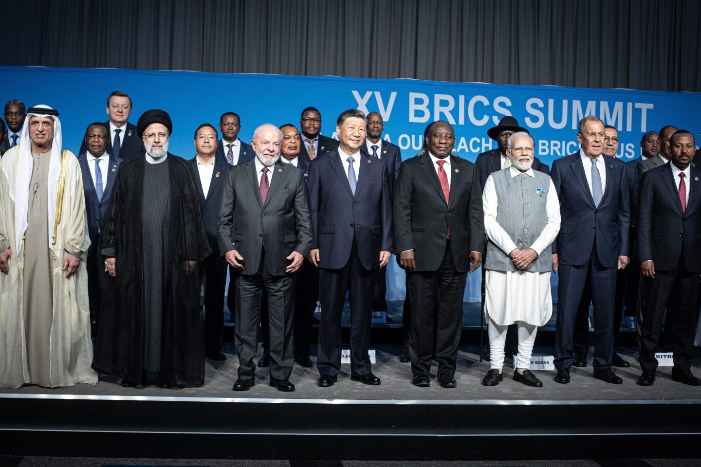 South African President Cyril Ramaphosa with fellow BRICS leaders President of Brazil Luiz Inacio Lula da Silva, President of China Xi Jinping, Prime Minister of India Narendra Modi, and Russia's Foreign Minister Sergei Lavrov pose for a photo, with delegates including six nations invited to join the BRICS group, Argentina, Egypt, Ethiopia, Iran, the United Arab Emirates and Saudi Arabia.