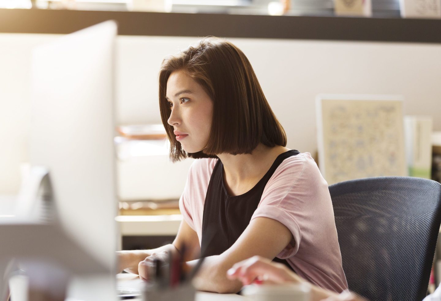 Young businesswoman using computer at desk in office