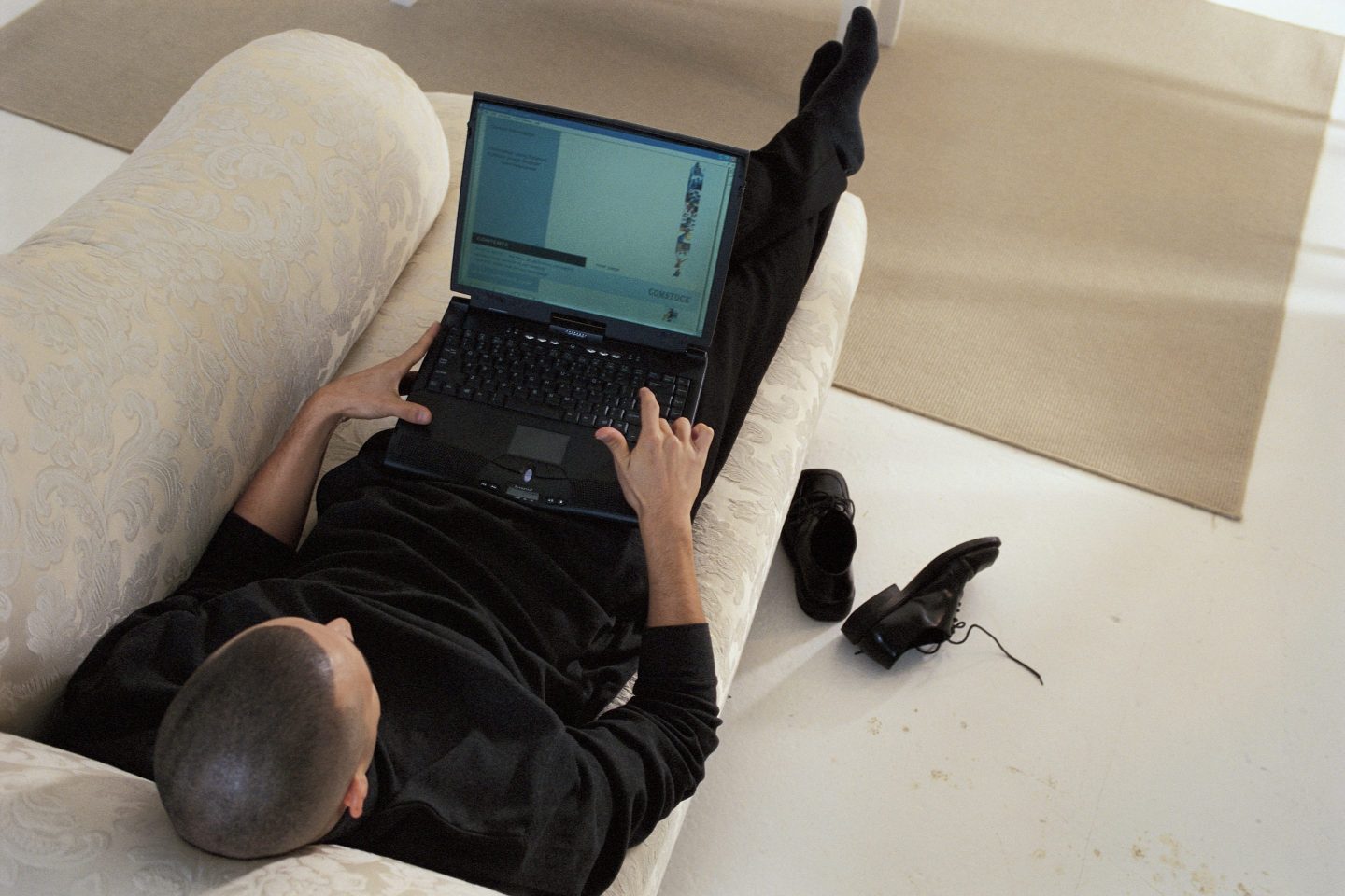 Man on couch using his laptop