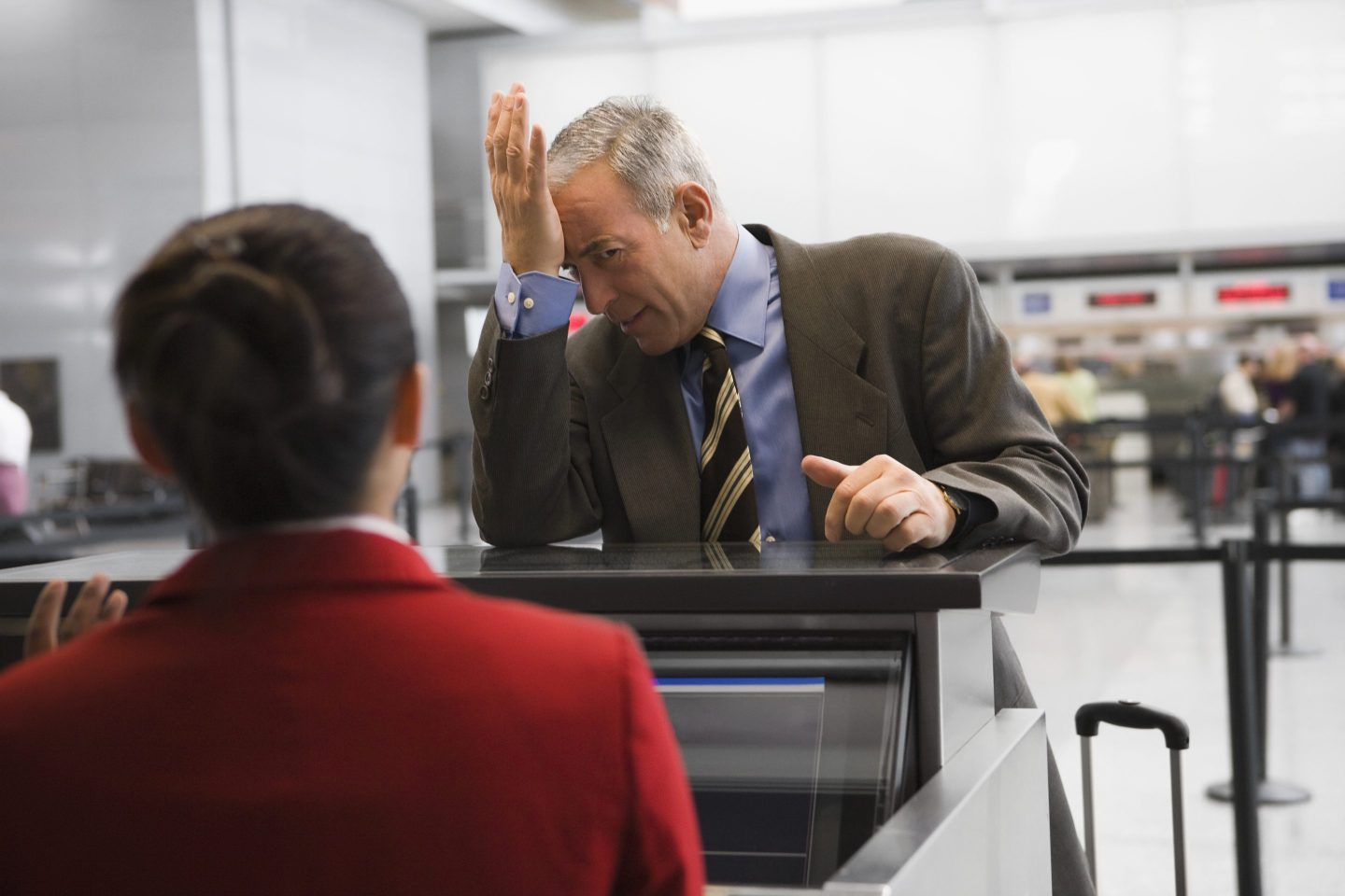 Businessman at airport check-in desk.