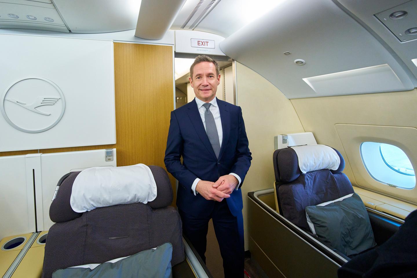 a picture of jens ritter standing inside a Lufthansa flight