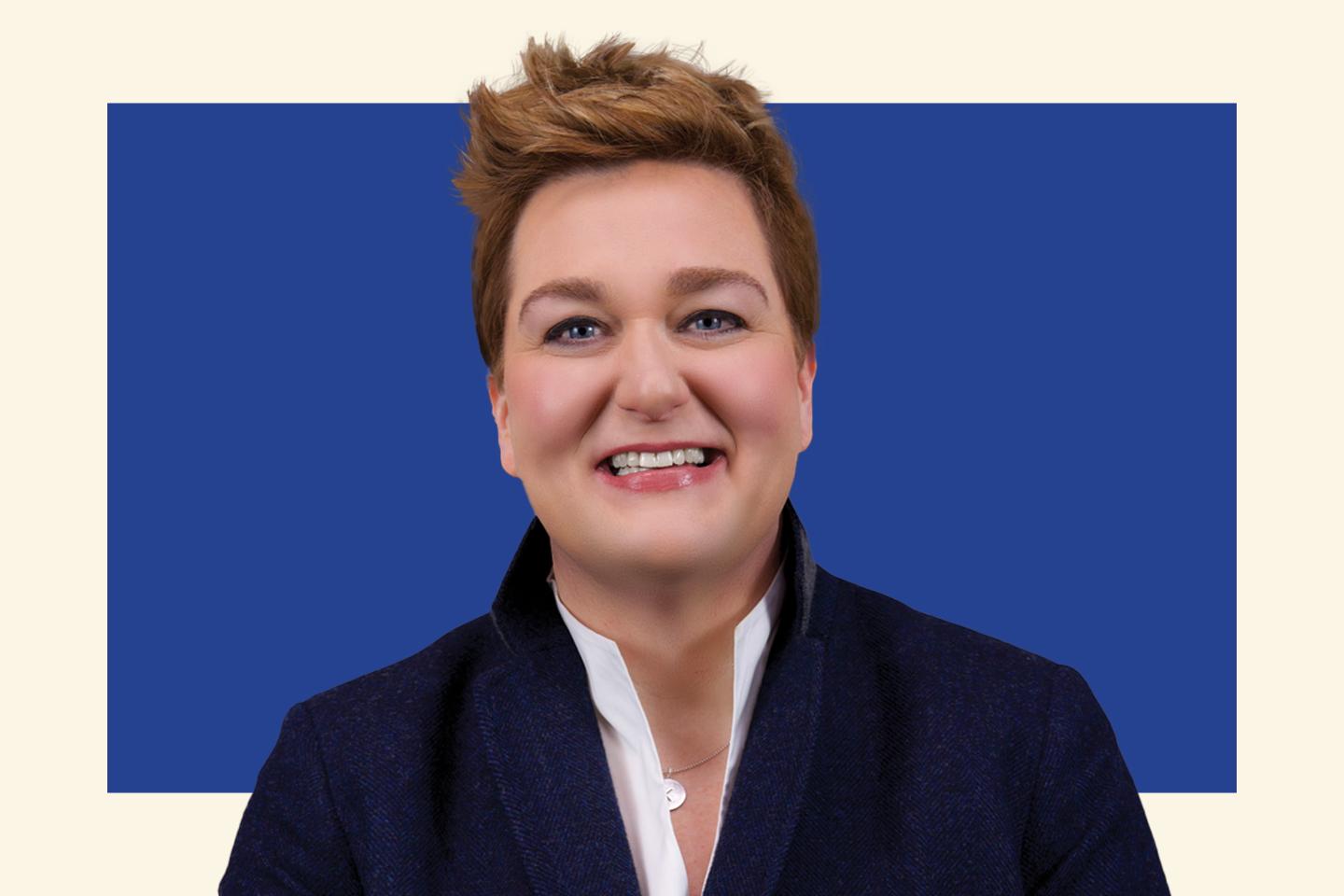 woman with short hair wearing a suit jacket, smiling