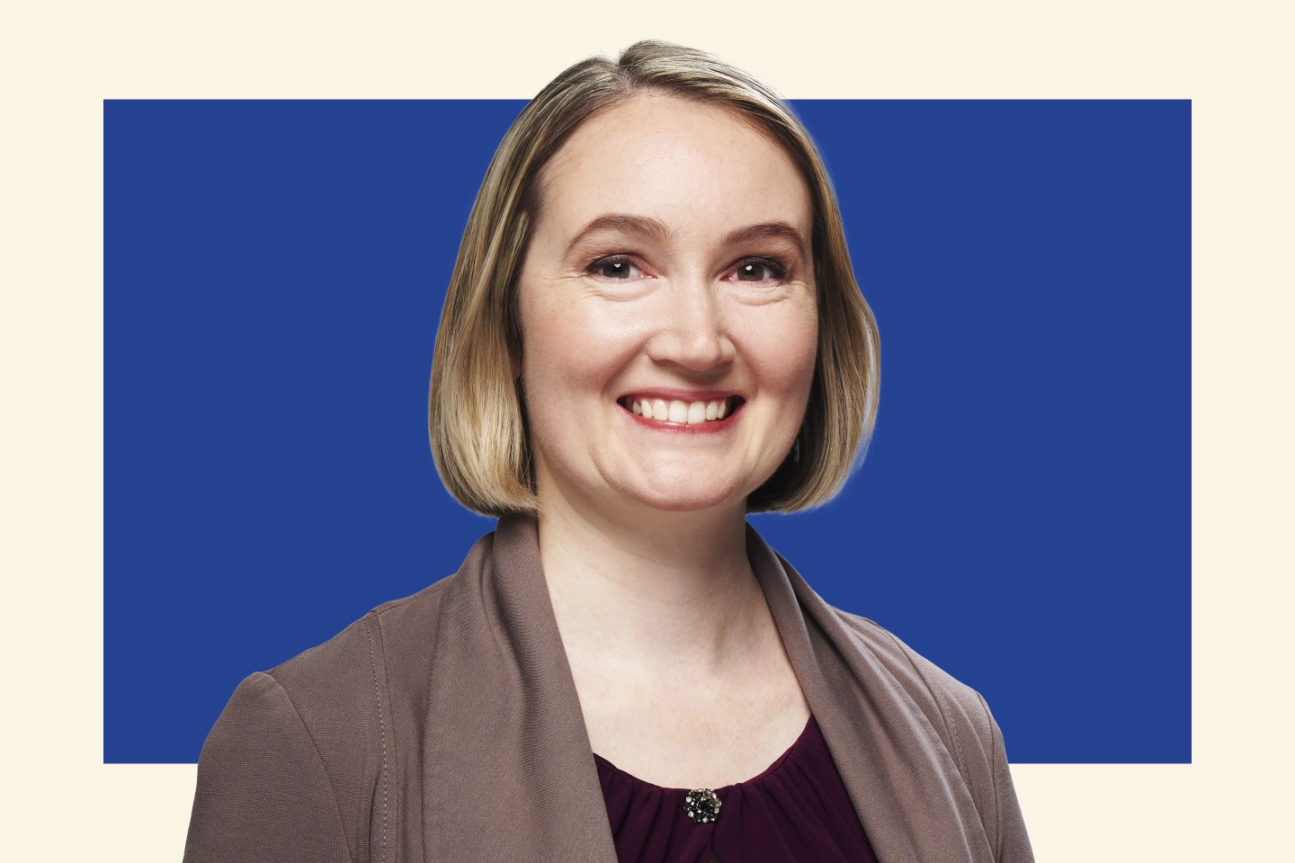 blonde woman in professional attire smiling towards camera