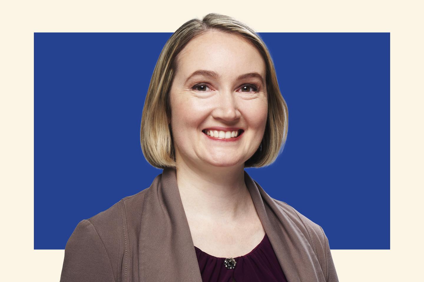 blonde woman in professional attire smiling towards camera