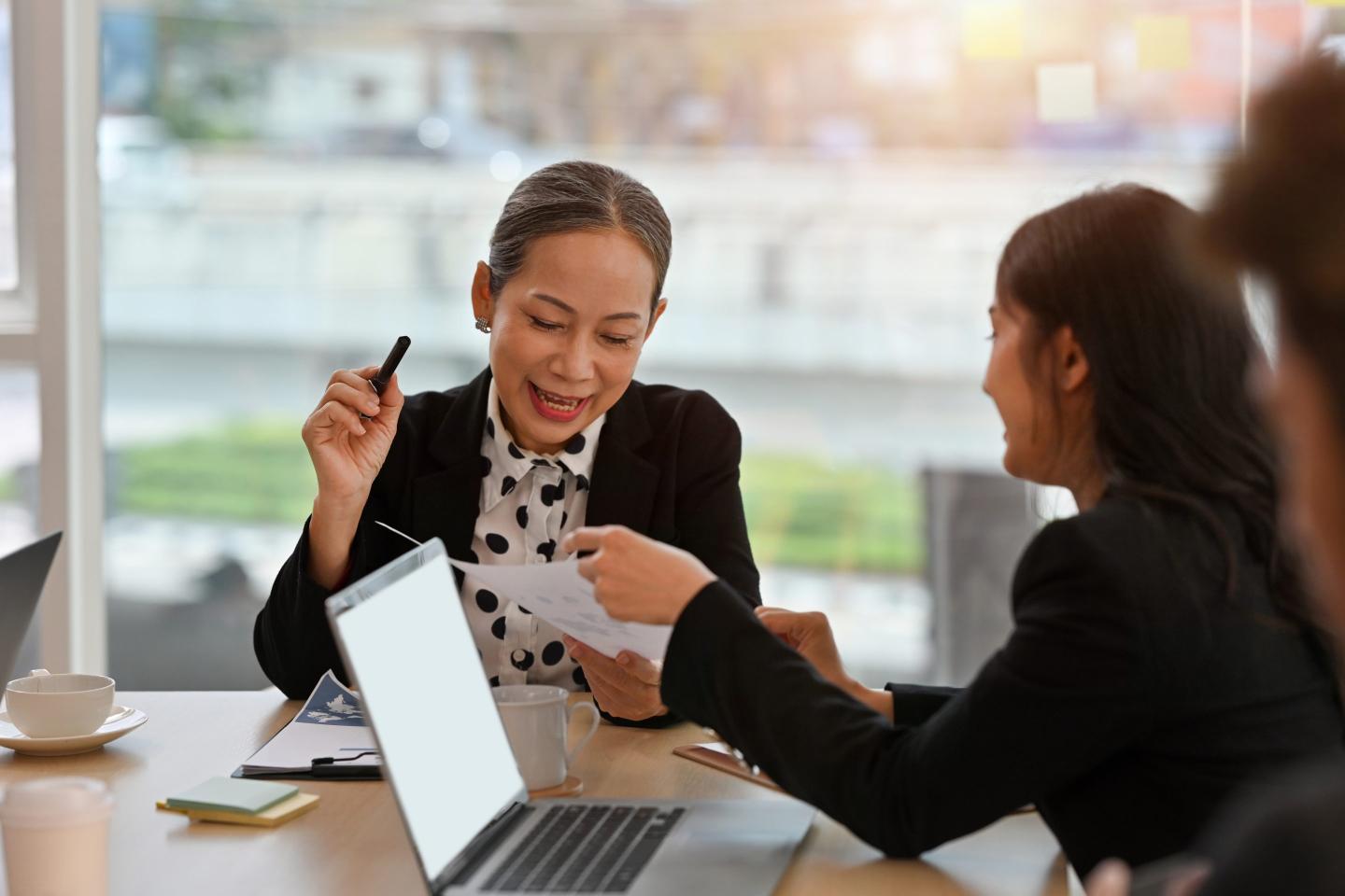 A senior executive woman runs a small commitee meeting