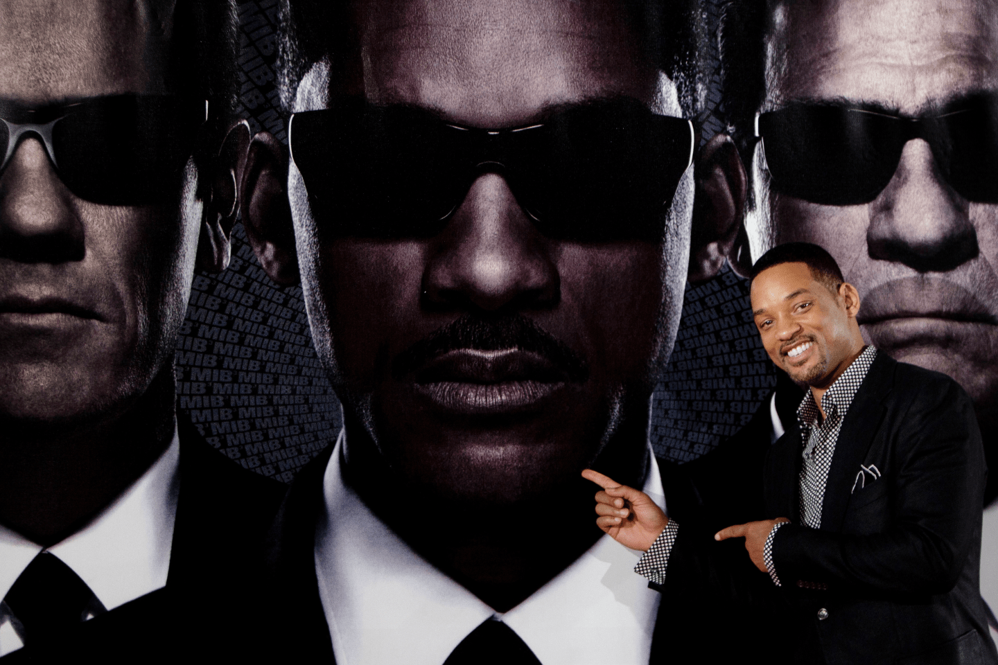 Will Smith in front of a Men in Black poster